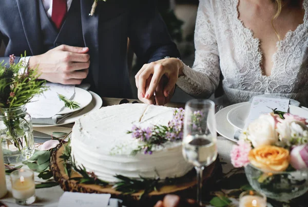 Bruid en bruidegom snijden taart — Stockfoto
