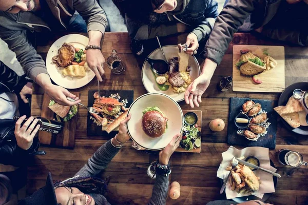 Amigos todos juntos no restaurante tendo refeição — Fotografia de Stock