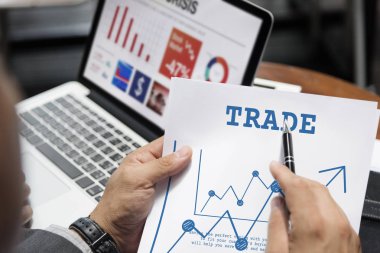 Kağıt sayfaya işaret eden takım elbiseli adam 