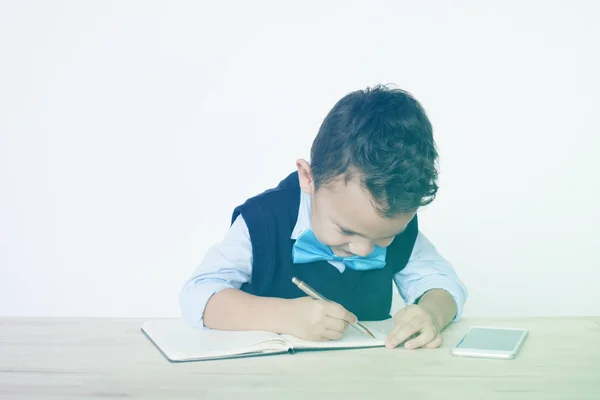 Skolpojke skriver i anteckningsbok — Stockfoto