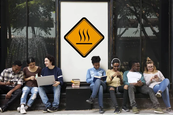 Mnohonárodnostní studenti sedí v ulici — Stock fotografie