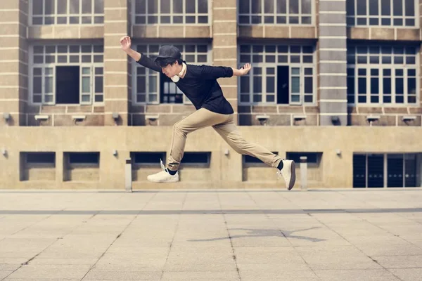 アジア人の男性が通りでジャンプ — ストック写真