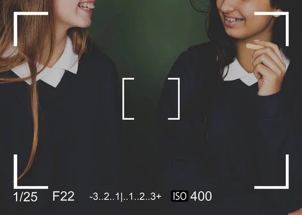 School girls talking at the chalkboard — Stock Photo, Image