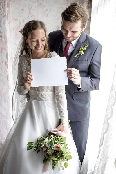 Mariée et marié tenant une pancarte blanche — Photo