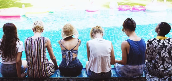 Meisjes zitten bij zwembad — Stockfoto
