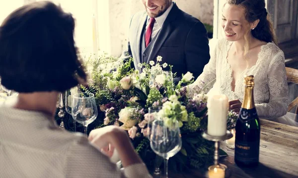 Bruid en bruidegom maaltijd met vrienden — Stockfoto