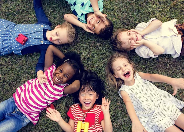 Kinderen liggen op het gras — Stockfoto