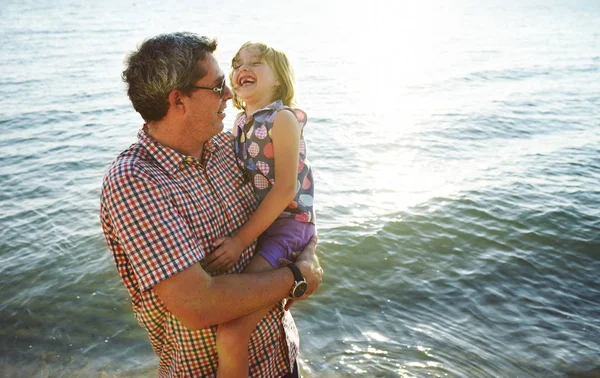 Pai carregando filha perto do mar — Fotografia de Stock