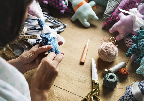 Mujer manos cosiendo suave muñeca juguete — Foto de Stock