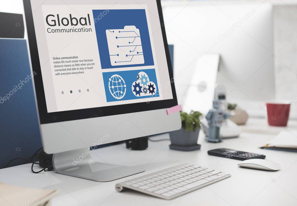 Computer monitor and keyboard on office desk, text: Global Communication