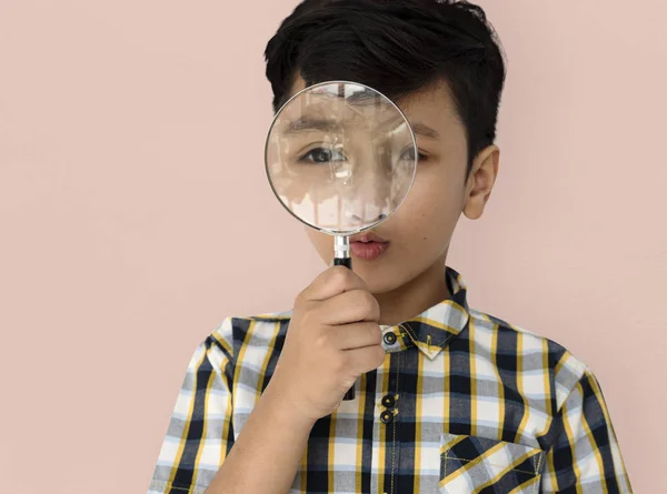 Boy looking in magnifying glass — Stock Photo, Image