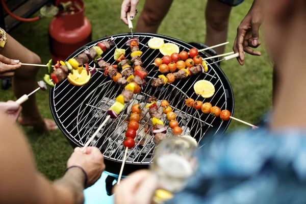 Amici che cucinano barbecue sui carboni — Foto Stock