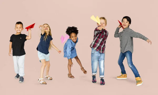 Niños lanzando aviones de papel — Foto de Stock