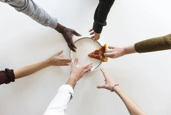 Händer nå för bit pizza — Stockfoto