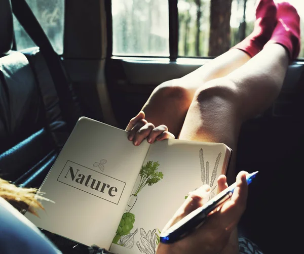 Kvinna sitter i bil med notebook — Stockfoto