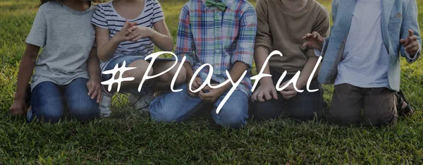 Groep kinderen zitten op gras — Stockfoto
