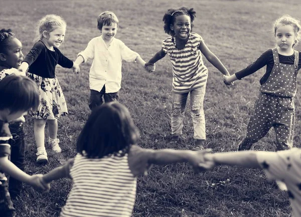 Dzieci trzymając się za ręce i odtwarzanie — Zdjęcie stockowe