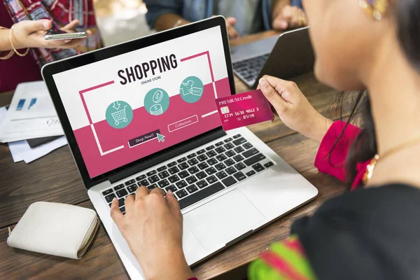 Bilgisayarı ve kredi kartı olan bir kadın.