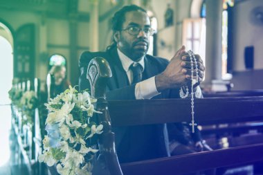 Kilisede dua eden bir adam.