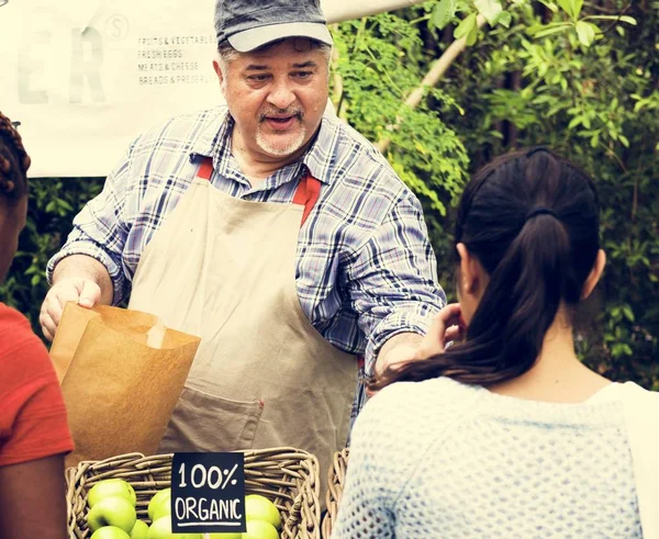 Propietario de la tienda de comestibles venta de productos al cliente — Foto de Stock