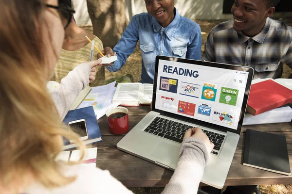 Schüler sitzen mit Büchern und Laptop am Tisch — Stockfoto