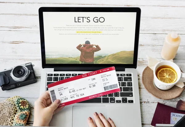 Handen op laptop en reizen ticket — Stockfoto