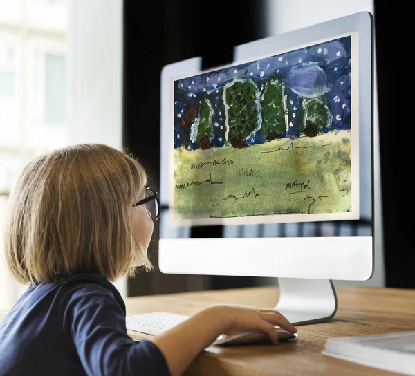 Маленькая девочка смотрит на экран монитора — стоковое фото