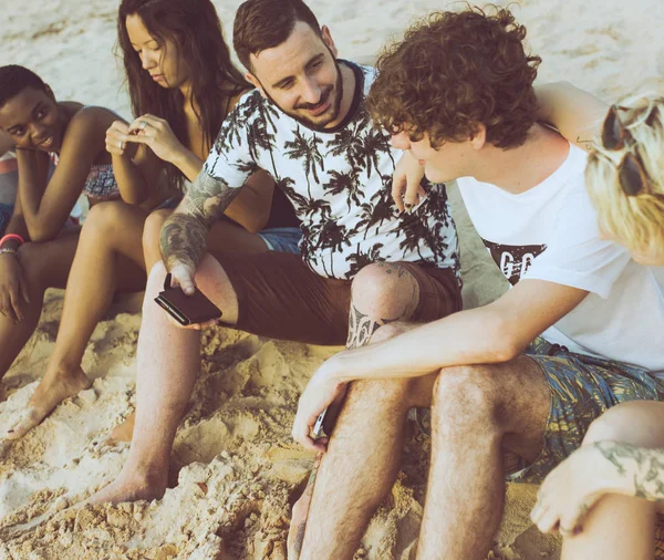 Друзі сидять на пляжі — стокове фото