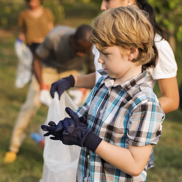 Junge sammelt Müll im Park — Stockfoto