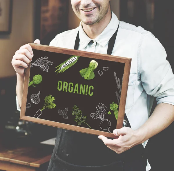 Man in black apron holding poster — Stock Photo, Image