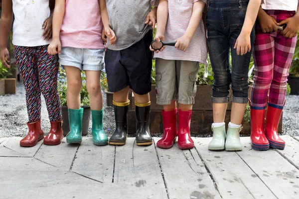 Barn bär färgglada gummistövlar — Stockfoto