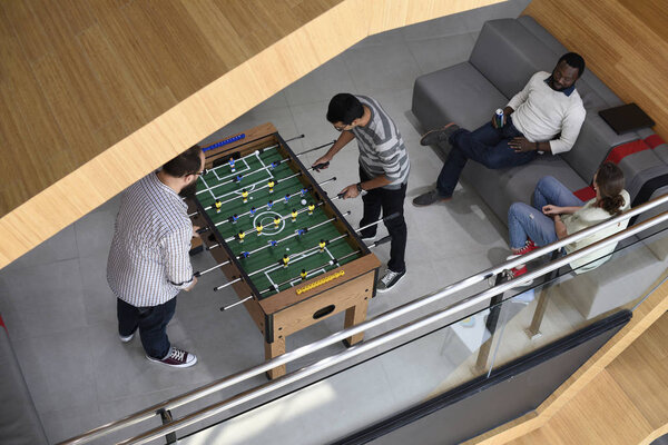 Office workers playing table football