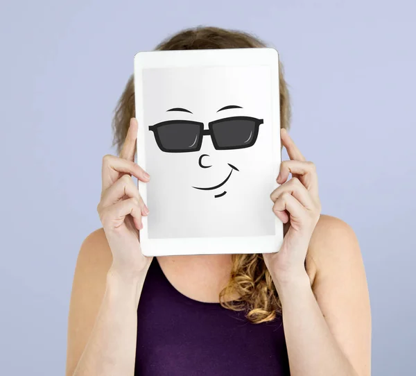 Kobieta trzyma cyfrowego tabletu obejmujący twarz — Zdjęcie stockowe