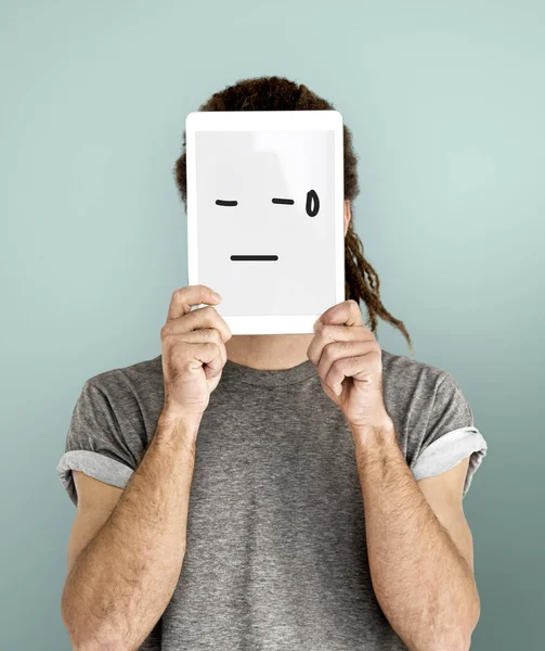 Hombre celebración de la tableta digital que cubre la cara — Foto de Stock