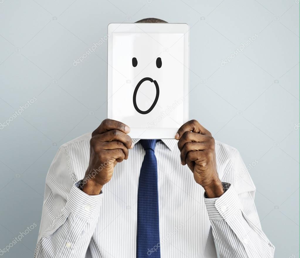Businessman covering face with digital tablet