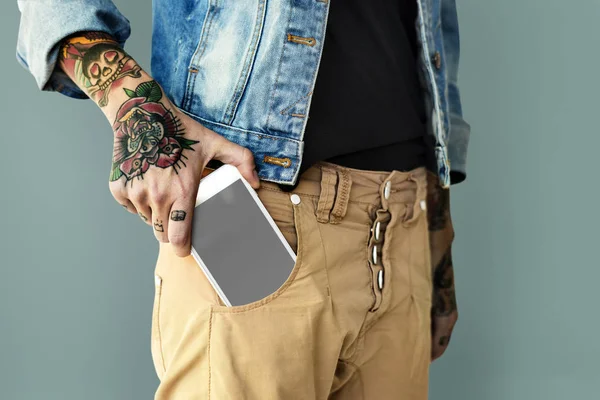 Hand steckt Smartphone in Tasche — Stockfoto