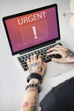 Dizüstü bilgisayarda yazarak dövmeli kadın eller