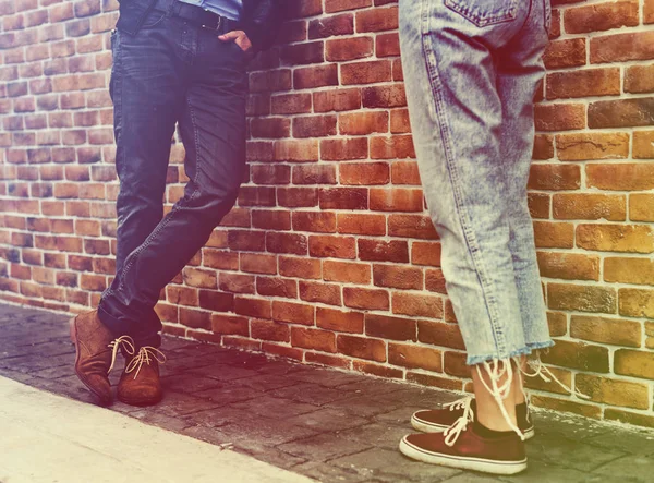 Pareja de pie cerca de pared de ladrillo —  Fotos de Stock