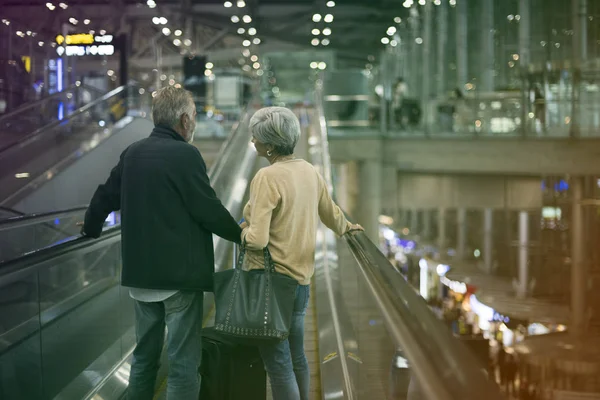 在机场的自动扶梯上的老年旅游市场 — 图库照片