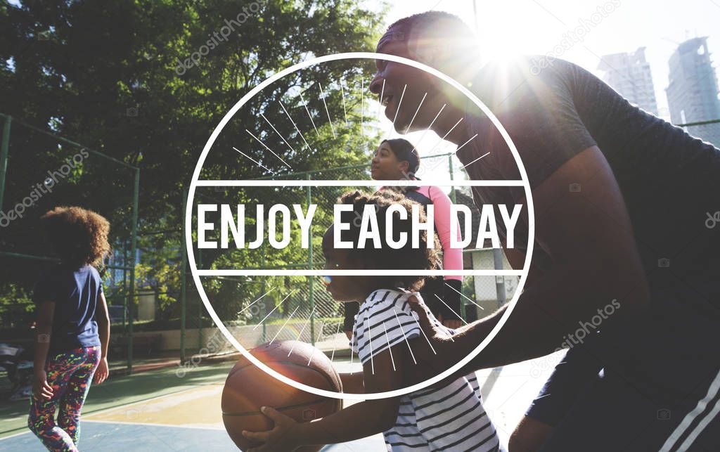 Active african family playing basketball together outdoors, text: Enjoy Each Day