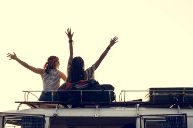 Van çatıda oturan insanlar