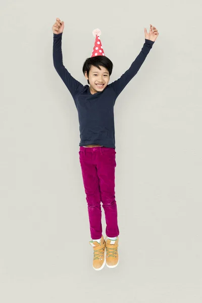 Boy jumping in birthday hat — Stock Photo, Image