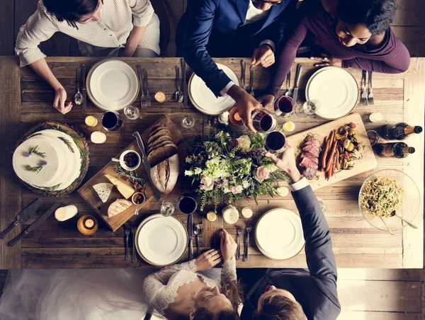 Braut und Bräutigam essen mit Freunden — Stockfoto