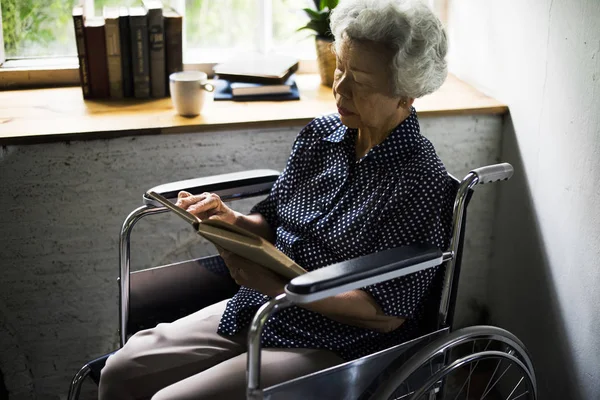 Kobieta na wózku inwalidzkim i czytanie książki — Zdjęcie stockowe