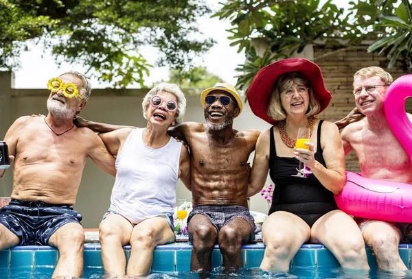 Lidé sedí na okraji bazénu — Stock fotografie