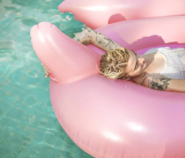 Donna galleggiante in piscina con gonfiabile — Foto Stock
