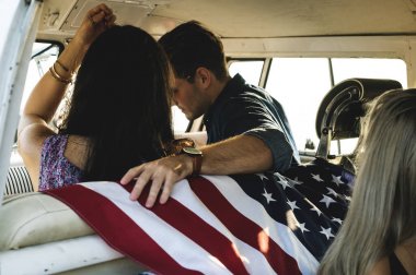 Amerikan bayrağı ile ön koltukta oturan insanlar