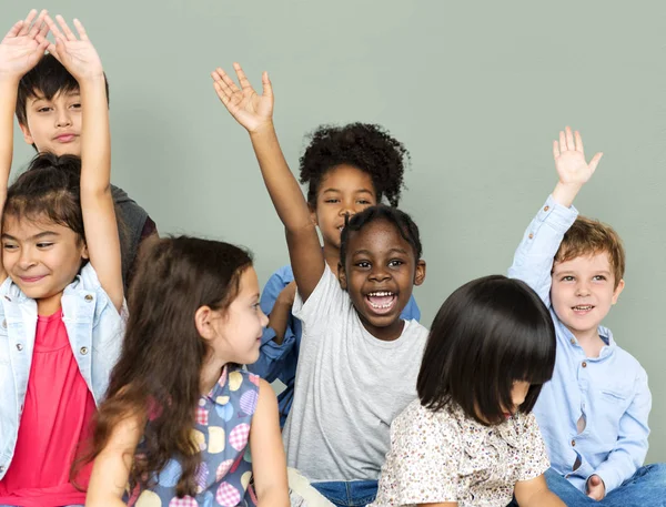 Crianças em idade escolar levantando as mãos — Fotografia de Stock