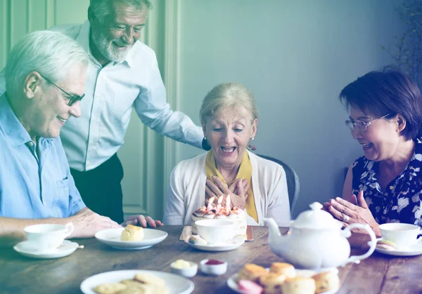 Donna anziana con amici e torta di compleanno — Foto Stock