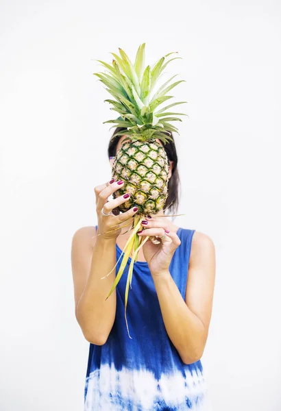 Женщина покрывает лицо ананасом — стоковое фото
